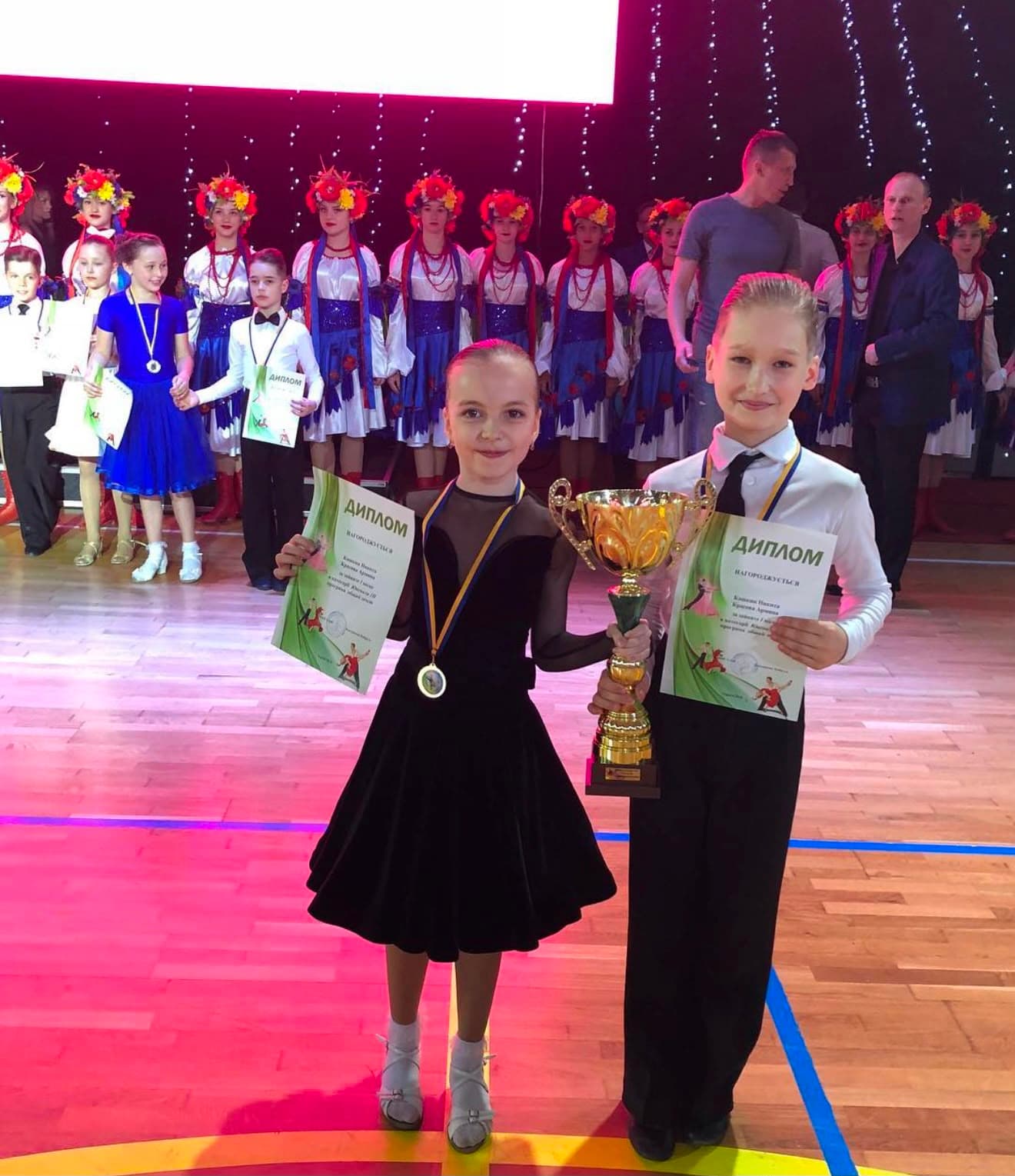 Kinderpaar mit Diplomen und Pokal beim Turnier
